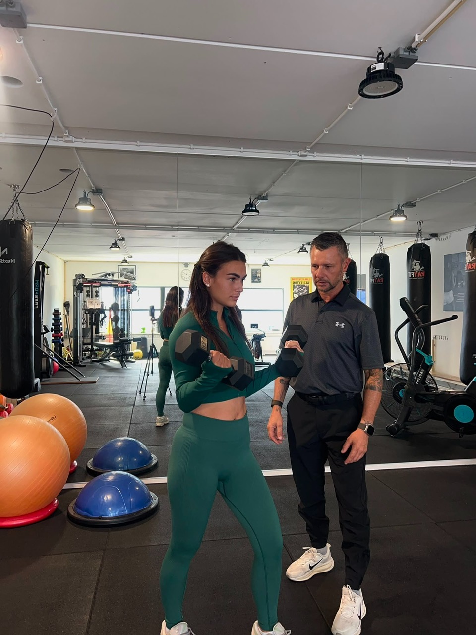 Privétraining met dumbbells onder begeleiding van de trainer